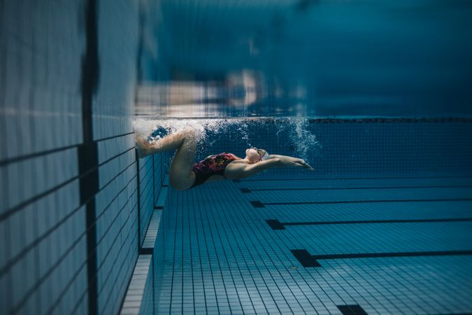 Female swimmer performing a flip turn in pool