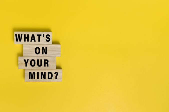 what's on your mind words on wooden blocks isolated on yellow background. copy space