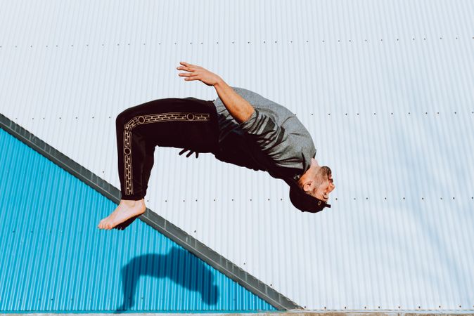 Trendy male flipping on street