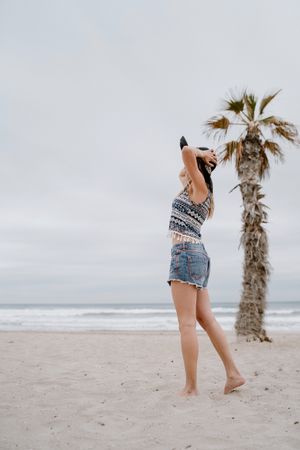 Young female relaxing on beach with hat