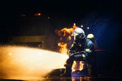 Anonymous fireman fighting fire with water