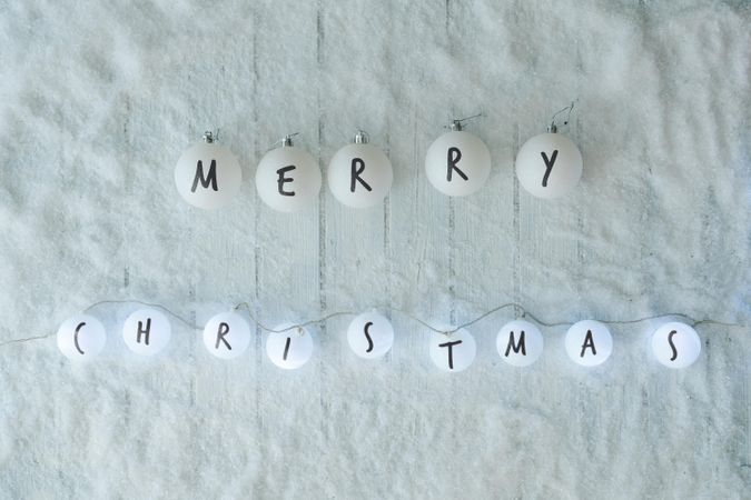 Snowy with partially lit ball decorations reading “Merry Christmas”