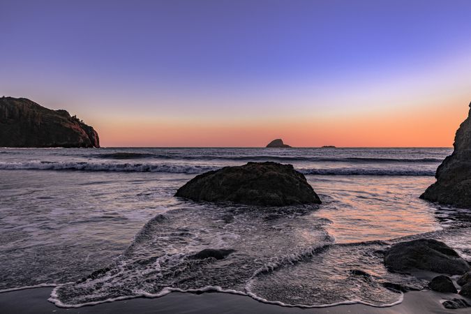 Rocky Pacific Ocean cliffs with clear colorful at sunset