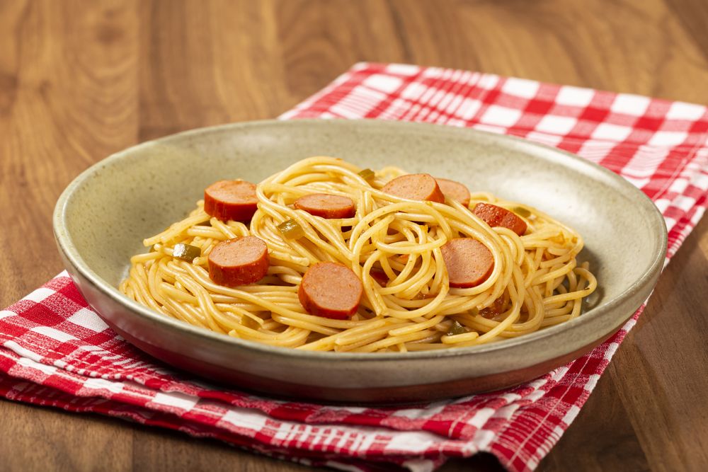 spaghetti pasta with sliced sausages and tomato sauce.