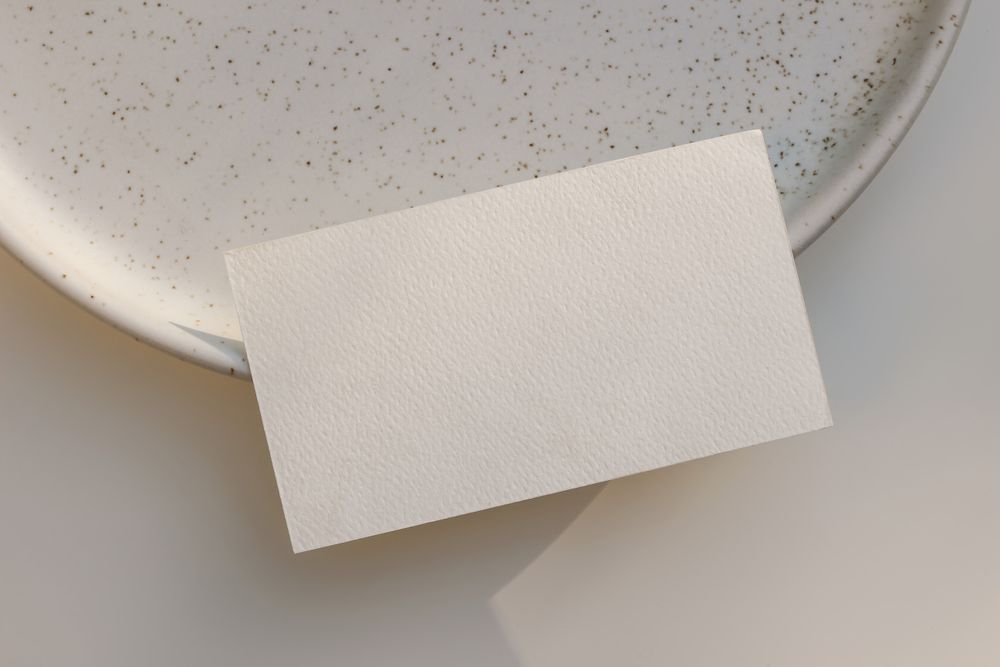 Mock up card balancing on edge of ceramic plate