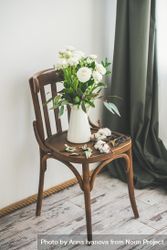 Spring buttercup flowers in enamel jug on chair bYvwY0