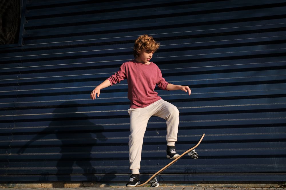 Boy doing stunt on skateboard on street