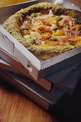 Margherita pizza with basil and tomato served with cold beer on checkered tablecloth