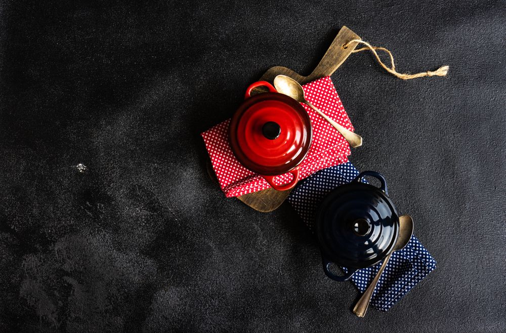 Top view of two red & blue cast iron pan on kitchen towels with copy space