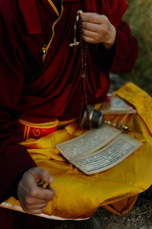 Close-up shot of a Buddhist monk holding prayer beads