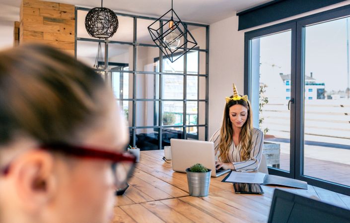 Businesswoman with unicorn headband working