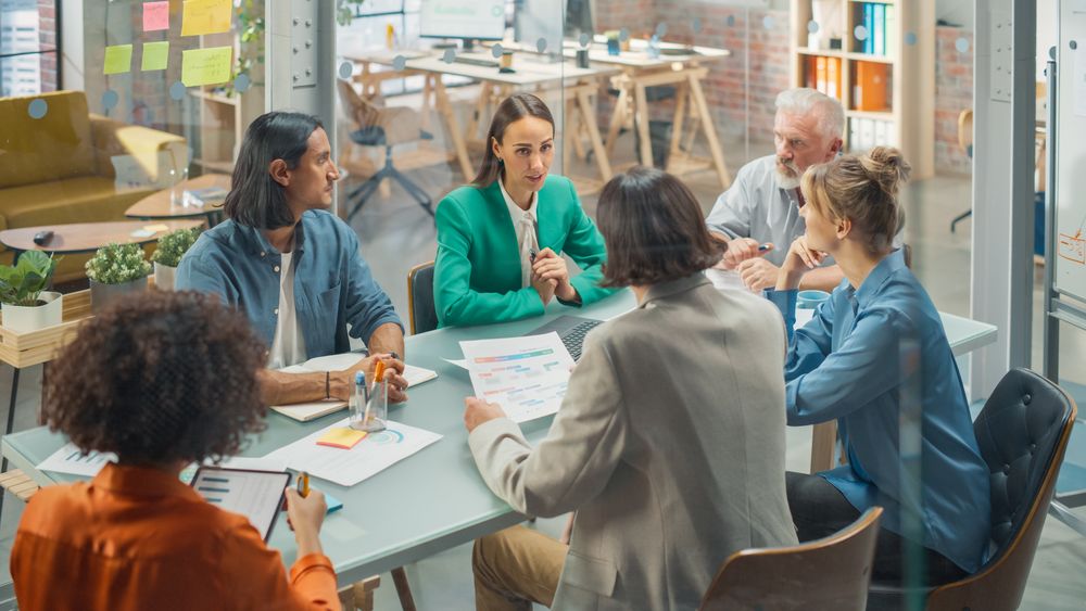 In the Stylish Modern Office Meeting Room: Diverse Group of Business Growth Marketing Professionals Use Laptop and Tablet