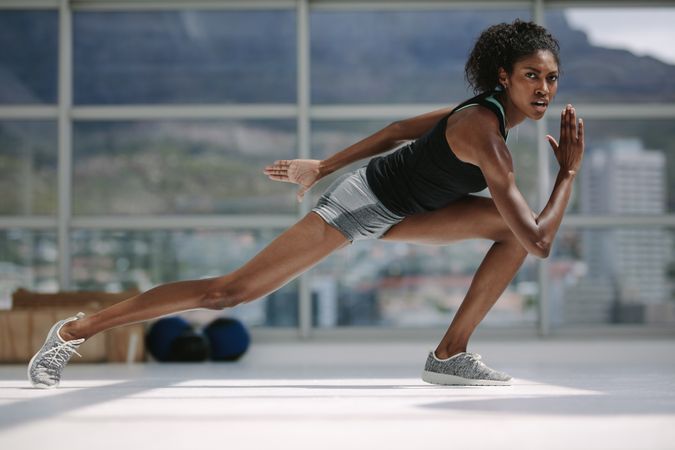 Slim Black woman exercising in gym