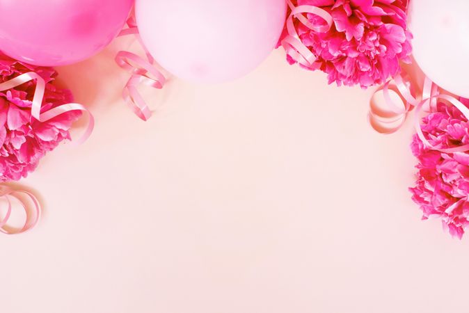 Pink birthday balloons and ribbon on pink background with copy space