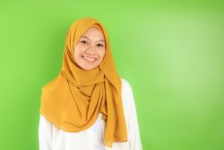 Indonesian Female Wear Mustard Veil Pose on Green Background