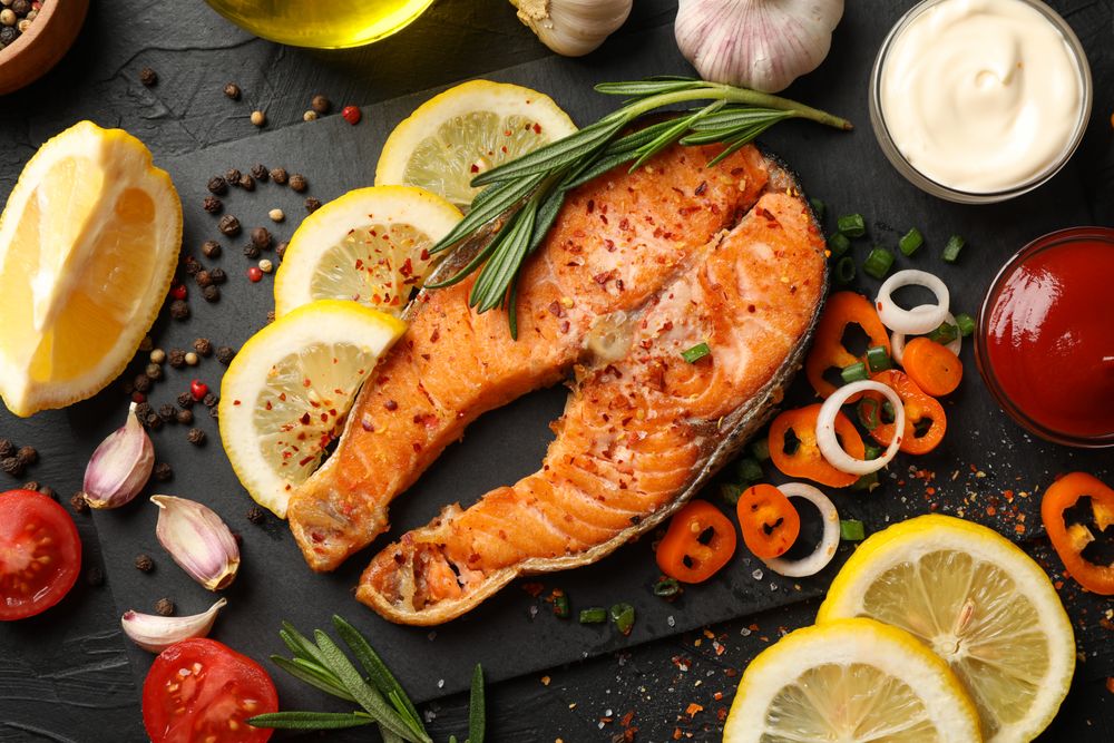 Composition with tasty grilled salmon on dark background, top view