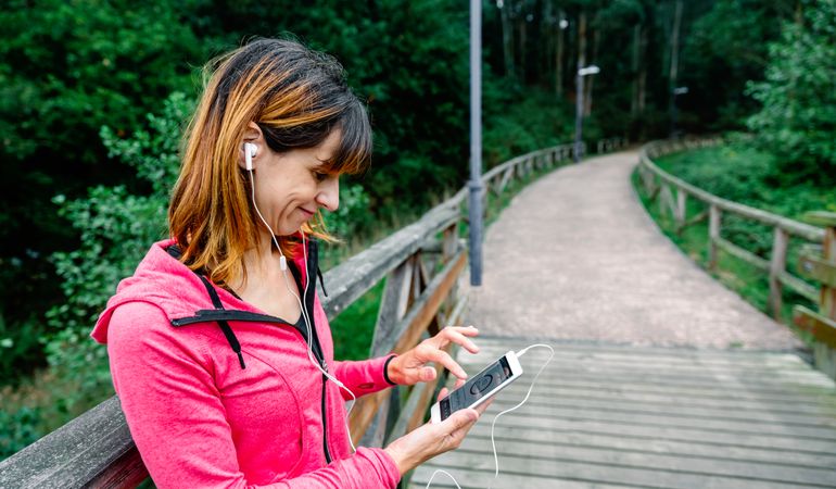 Athlete woman with earphones looking mobile