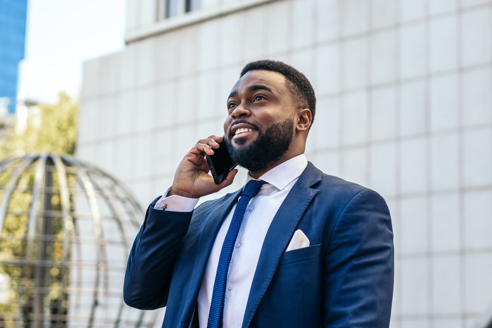 Business man in suit talking on the phone while leaving the office