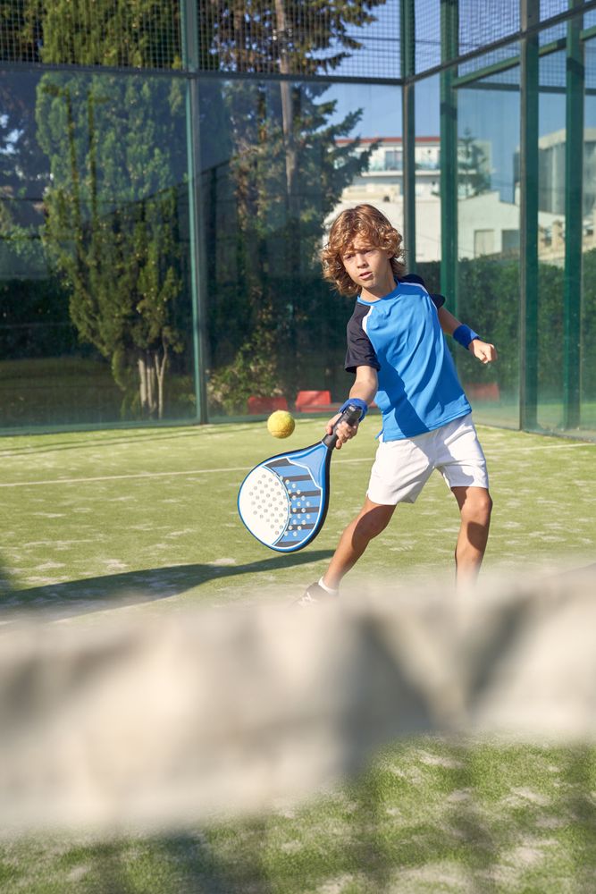 Boy hitting ball with racket