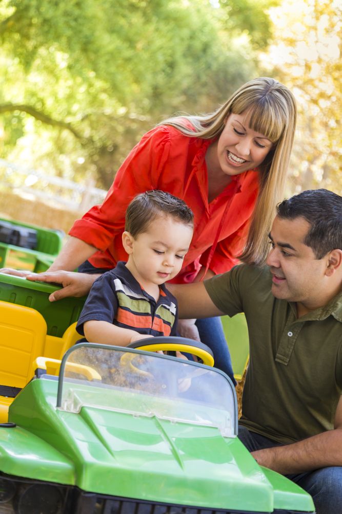Young Boy Enjoys Toy Tractor with Parents