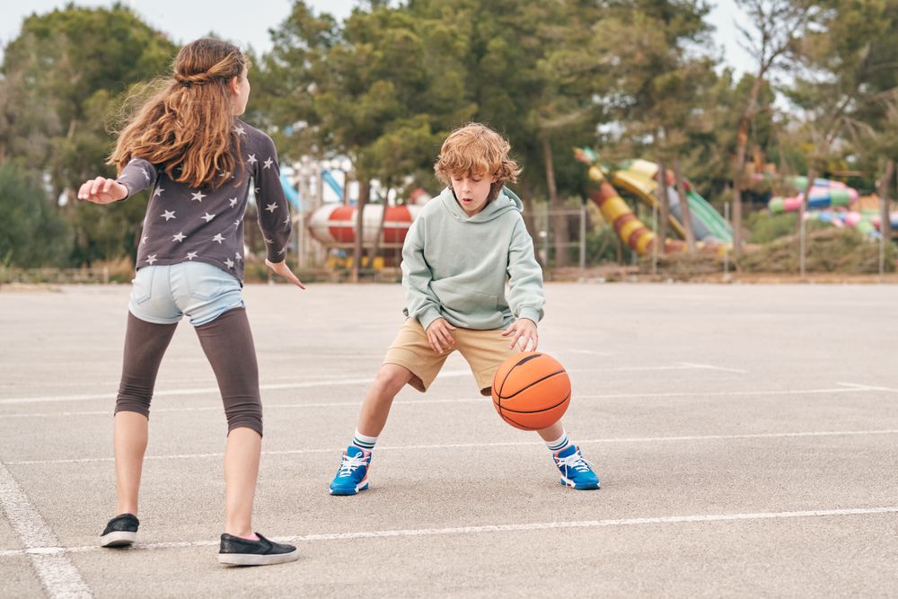 Teenagers playing basketball together in city