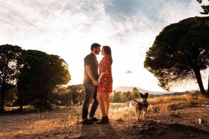 Happy couple with friendly cute dog outdoors