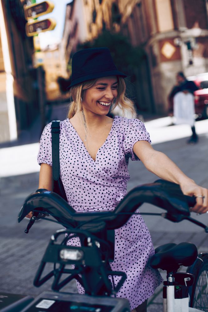 Young woman taking a rental bike in city