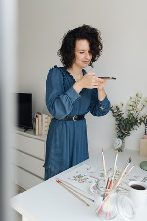 Artist photographing drawings with smartphone