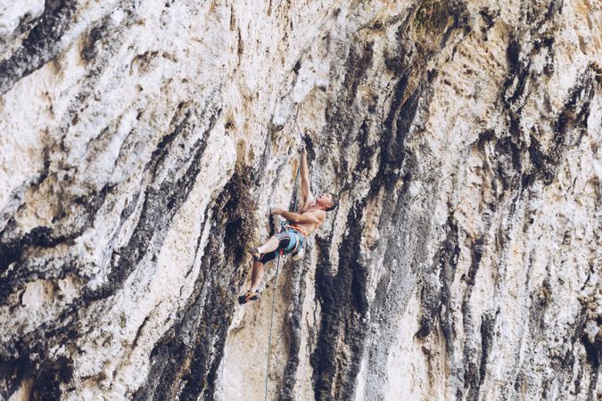 Anonymous man climbing rock