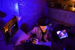 Woman with microphone and headphone working on a computer