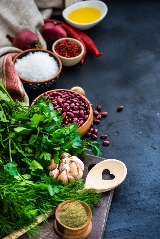 Vertical shot of kitchen counter with seasonings, herbs and dried beans