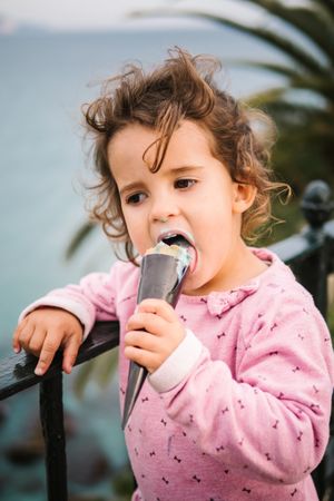 Adorable serious toddler girl with ice-cream