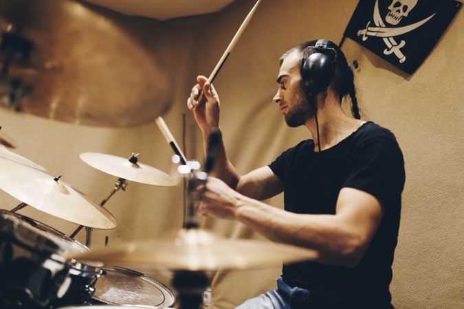 Man with headphones playing on drums