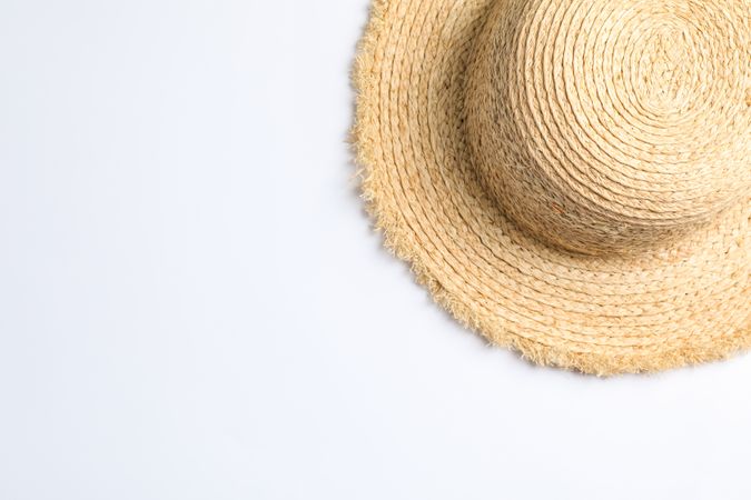 Pretty straw hat on neutral background. Space for text, top view