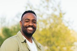 smiling Black young man portrait in a park