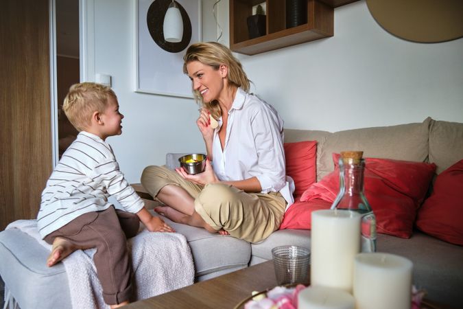 Happy mother and son sitting on sofa