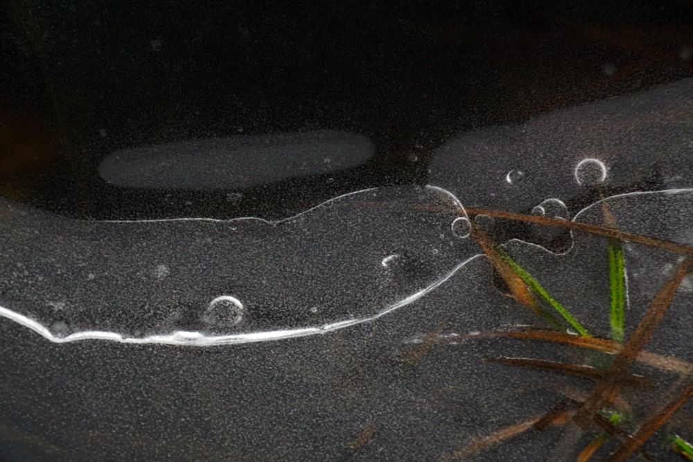 Fragment of thin ice on dark frozen river