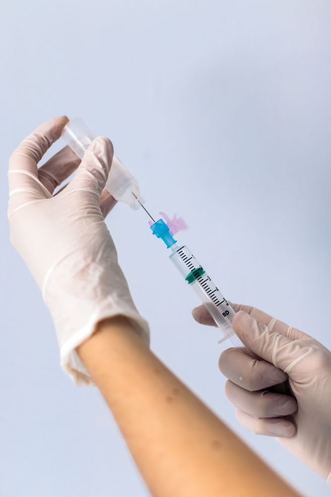hands with syringe injecting serum.
