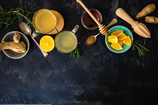 Ginger detox drinks and ingredients on dark counter with copy space