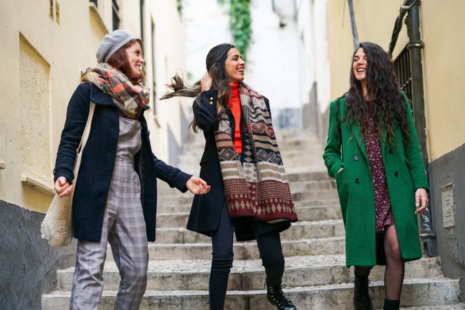Three well dressed female friends talking together on a walk