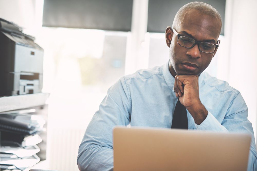 Man reading something on his laptop in the home office