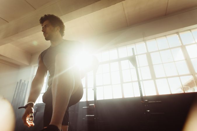 Focused male athlete standing at cross training gym