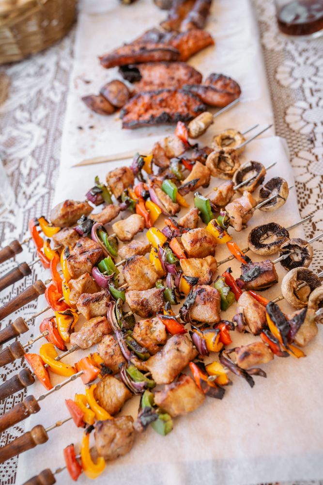 top view of plate with skewers sticks of pork with vegetables and chorizo
