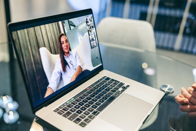 Businesswoman on screen of laptop attending a video conference in an office