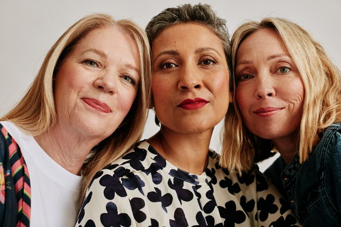 Three women with faces together in close up portrait
