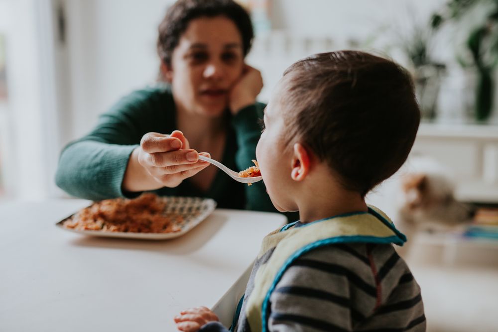 Woman feeding toddler