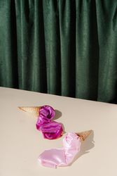 Waffle cones lying on stage with pink fabric on green curtain background