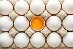 chicken eggs in carton box as background, top view