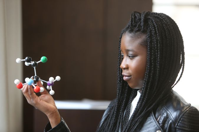 Young woman holding molecular model