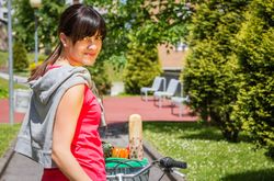 Young sportive woman with groceries in a basket bike